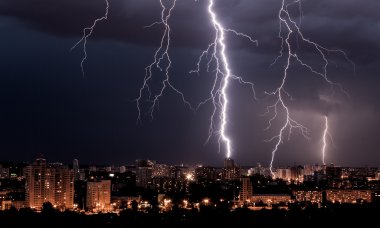Lightning storm over city at night clipart