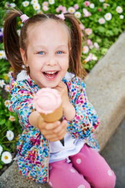 Waffle külahında dondurmayla gülen kız dışarıda bankta oturuyor. Tatil, tatil ve yaz zamanı konsepti