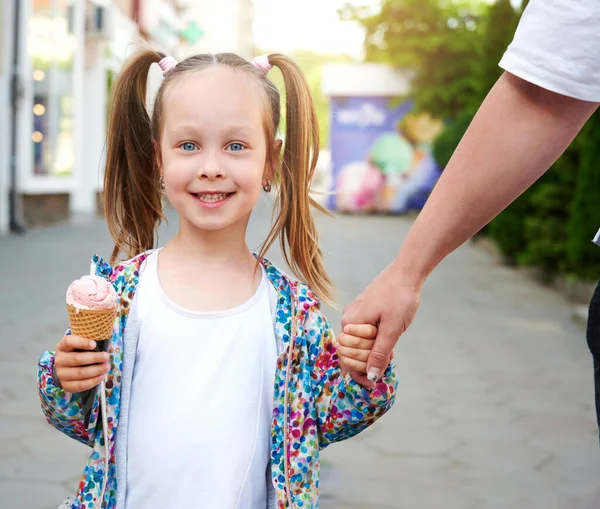 笑着的孩子拿着冰淇淋和她妈妈一起走 背景的冰淇淋店 — 图库照片