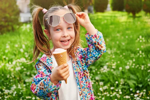 手里拿着冰淇淋笑着的小女孩把太阳镜举到额头上 假期和夏季时间概念 — 图库照片