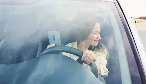 Una Mujer Joven Conduciendo Coche Con Teléfono Una Mano Mira — Foto de Stock