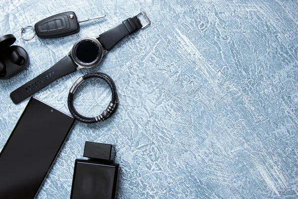 Herrenuhren, Brillen, Smartphones, Accessoires. Schwarze Accessoires auf grauem Hintergrund — Stockfoto