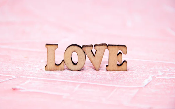 The inscription love on a pink background. Wooden letters. The inscription I love you in wooden letters on a pink background. — Stock Photo, Image