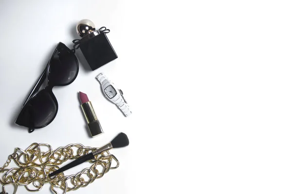 Vrouwen accessoires in zwart en cosmetica op een witte achtergrond. Top weergave van het bureaublad voor vrouwen Stockfoto