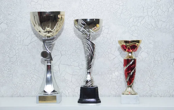 Cups and awards on the shelf. The prize is a trophy for the winner of the exhibition on the shelf. Stock Photo