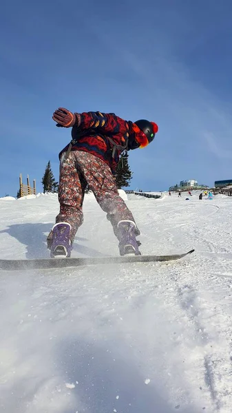 Facet jeździ na snowboardzie. Aktywny snowboardzista, zjeżdżający ze wzgórza, z bliska snowboarding. Zdjęcie pionowe — Zdjęcie stockowe