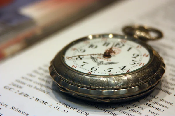 Oude zakhorloge liggend op het boek met tekst in de Engelse — Stockfoto