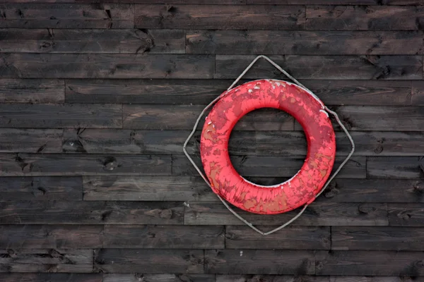 Old life preserver on the wall of brown boards Stock Photo