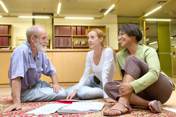 Professor with students sit on carpet — Stock Photo, Image