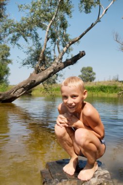 Kaya Gölü içinde oturan mutlu ıslak çocuk