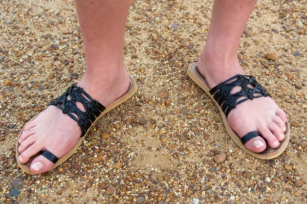 Feet in black sandals — Stock Photo, Image