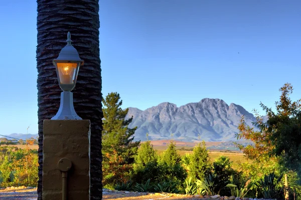 Lamp, palm tree, mountains — Stock Photo, Image