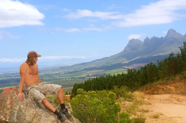Mladý muž se dívá na horách — Stock fotografie