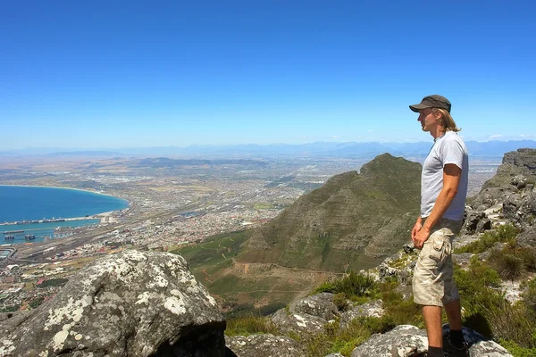 Young hiker looks at port city — Stock Photo, Image