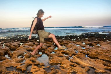 kadın backpacker kumsalda yürür