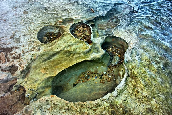 "Craters" on rocky sea beach — Stock Photo, Image