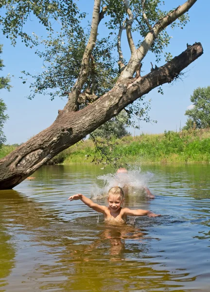 Glada barn spela i sjön — Stockfoto