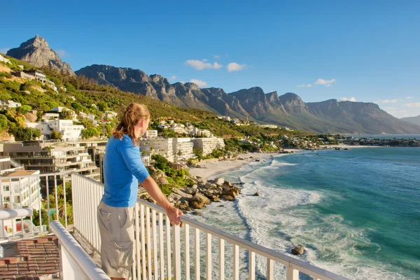 Ung man på terrassen ser på stranden panorama — Stockfoto