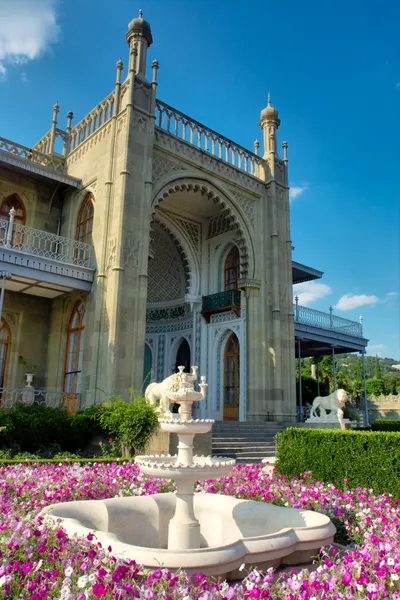 stock image Flower bed with vase fountain in front of palace