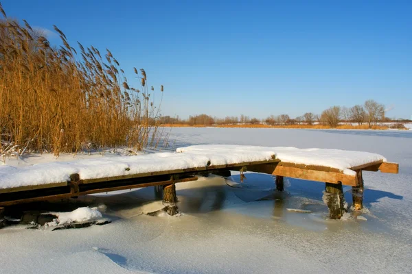 Pequeño amarradero de madera en nieve — Foto de Stock