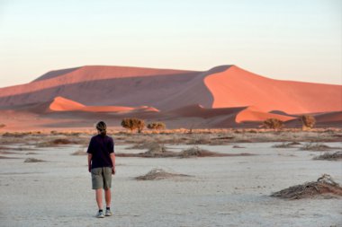 Görkemli kırmızı dunes karşı yürüyen kadın