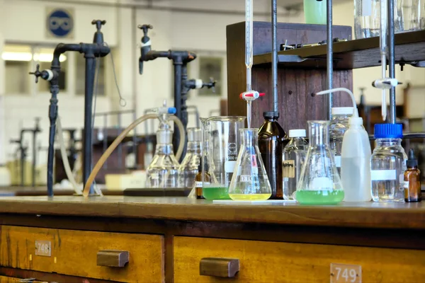 Szkło na drewnianych stołach w laboratorium chemicznym — Zdjęcie stockowe