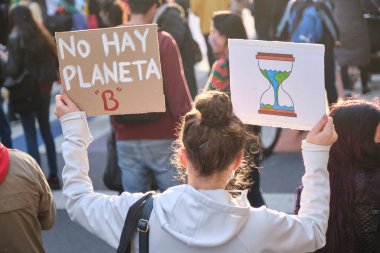 Buenos Aires, Arjantin; 24 Eylül 2021: Küresel İklim Grevi, Dünya 'nın zamanının tükendiğini simgeleyen bir tabelayla arkadan görülen kadın, B gezegeni yok