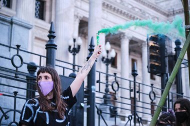 Buenos Aires, Arjantin; 24 Eylül 2021: Küresel İklim Grevi, tek kollu genç eylemci, Ulusal Kongre 'de yeşillik yıkamaya karşı bir gösteri kapsamında yeşil ışık yaktı.