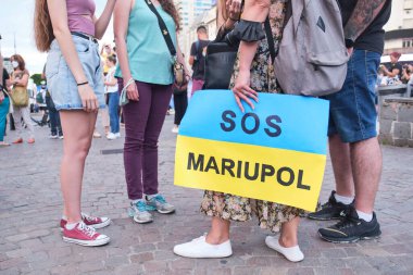 Buenos Aires, Arjantin; 6 Mart 2022: Rus savaşı ve işgaline karşı Ukrayna 'da barış için yürüyüş. Ukrayna bayrağı taşıyan tanınmayan genç kadın SOS Mariupol yazısıyla.