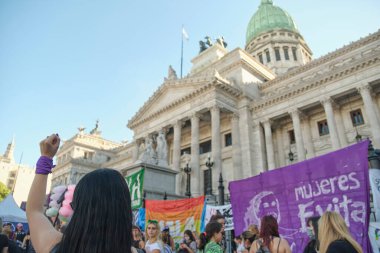 Buenos Aires, Arjantin; 8 Mart 2022: Uluslararası feminist grev, tanınmayan bir kadın Ulusal Kongre önünde feminist mücadelenin sembolü olan mor bir eşarpla yumruğunu kaldırdı.