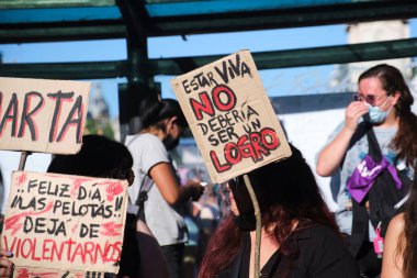 Buenos Aires, Arjantin; 8 Mart 2022: Uluslararası feminist grev sırasında tabela tutan kadınlar: Hayatta olmak bir başarı olmamalı. Mutlu bir gün değil, bize şiddet uygulamayı bırak..
