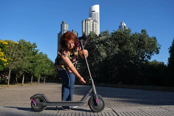 Spaanse Volwassen Vrouw Ontvouwt Haar Elektrische Kick Scooter Een Stadspark — Stockfoto