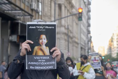 Başkent Federal, Buenos Aires, Arjantin; 11 Kasım 2021: Üzerinde böcek ilacı kurbanı bir çocuğun fotoğrafı olan bir tabela tutan tanınmayan kişi.