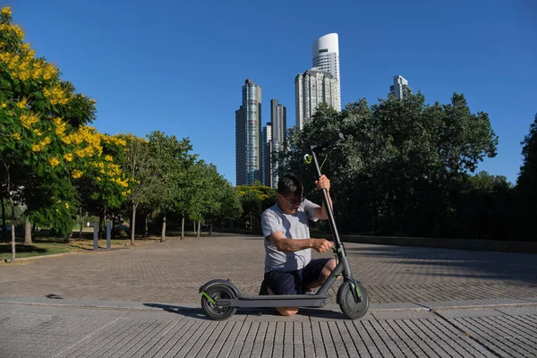 Spaanse Senior Man Ontvouwt Haar Elektrische Kick Scooter Een Stadspark — Stockfoto