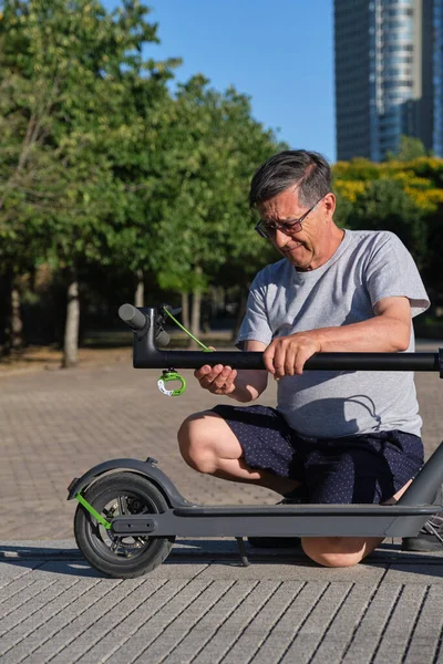 在一个阳光明媚的早晨 一位拉丁老人在一个城市公园里展示他的电动车 绿色交通 生态交通和城市活跃生活的概念 — 图库照片
