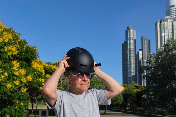 市内の公園でスポーツヘルメットをかぶっている上級のヒスパニック系男性 積極的な都市生活の概念 良いと道路の安全を感じます — ストック写真