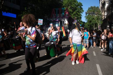 Buenos Aires, Arjantin; 6 Kasım 2021: LGBT Onur Yürüyüşü. Yürüyüş yapan ve müzik çalan renkli bir grup. Kapsamlı trans yasasını talep eden bir imza..