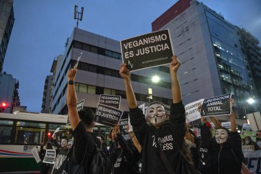 Buenos Aires, Arjantin; 1 Kasım 2021: Dünya Vegan Günü. Gün batımında Corrientes Caddesi 'nde yürüyen aktivistler ellerinde posterlerle: Vejetaryenlik adalettir..