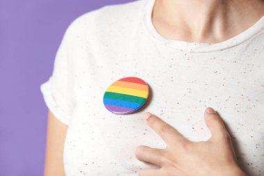 Gökkuşağı rozeti takan ve işaret eden bir kadın, LGBT topluluğuna destek sembolü. Geylerin, lezbiyenlerin, biseksüellerin ve tranların gururu, cinsel yönelim çeşitliliğine ve cinsiyet kimliğine saygı.