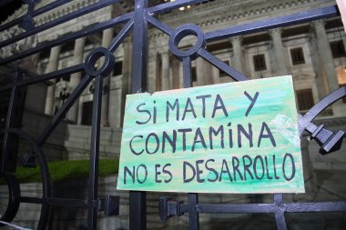 Buenos Aires, Arjantin; 22 Nisan 2022: Dünya Günü gösterimi, metni çevreci poster Öldürür ve kirletirse, Arjantin Ulusal Kongresi önünde gelişme değildir..