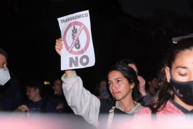 Buenos Aires, Arjantin; 21 Mayıs 2022: Tarımda GDO ve böcek ilaçlarını protesto eden insanlar. Genç bir kadın, genetiği değiştirilmiş HB4 buğdayının yetiştirilmesine karşı bir işaret taşıyor..