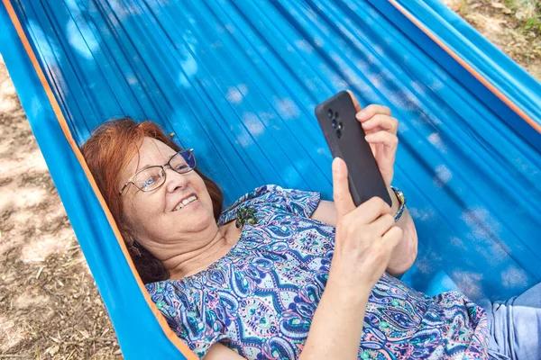 Mulher Madura Hispânica Com Óculos Sorrindo Usando Seu Telefone Inteligente — Fotografia de Stock