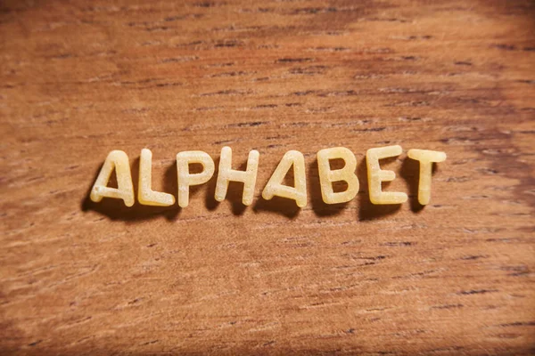 Wortalphabet Geformt Mit Buchstaben Aus Nudelsuppe Auf Einem Hölzernen Hintergrund — Stockfoto