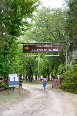 27 Aralık 2021; Entre Rios, Arjantin: Kırsal ve eko-turizm merkezi La Aurora del Palmar 'ın girişine doğru yürüyen kadın.