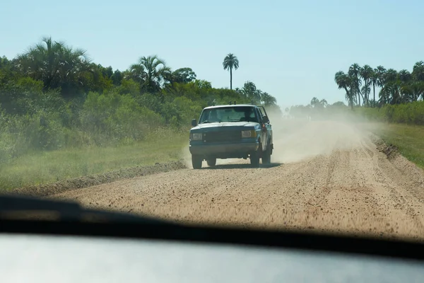 Traveling by car on a dirt road inside El Palmar National Park, in Entre Rios, Argentina, a protected area where the endemic Butia yatay palm tree is found.