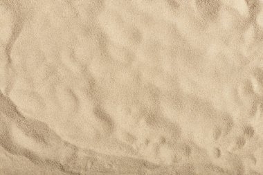 Doğal doku: plaj kumunun üst görüntüsü, temiz, pürüzsüz ve pürüzsüz. Yaz konseptleri, seyahatler, tatiller ve açık hava keyfi için minimalist altyapı.