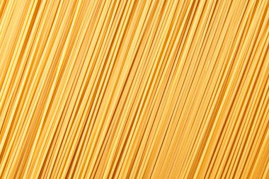 Italian food background, raw spaghetti filling the frame in a textured design of diagonal pasta lines.