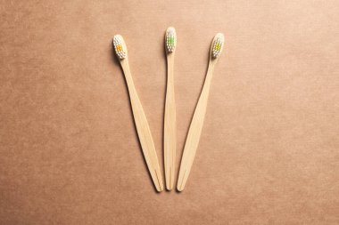 Set of three ecological bamboo toothbrushes. Concepts: sustainable lifestyle, use of compostable and environmentally friendly materials, zero plastics. Studio shot with copy space.