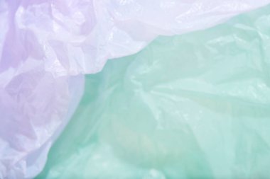 Green and purple background, single use plastic bags. Concepts: sustainability, recycling, pollution.