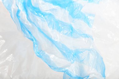 Plastic single use bags. Blue and white wrinkled background. Concepts: sustainability, recycling, pollution.